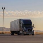 Une semi-remorque stationnée reliée à un camion par des attelages Premier Mfg