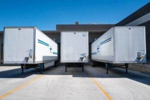 Three parked trailers waiting to be attached to trucks